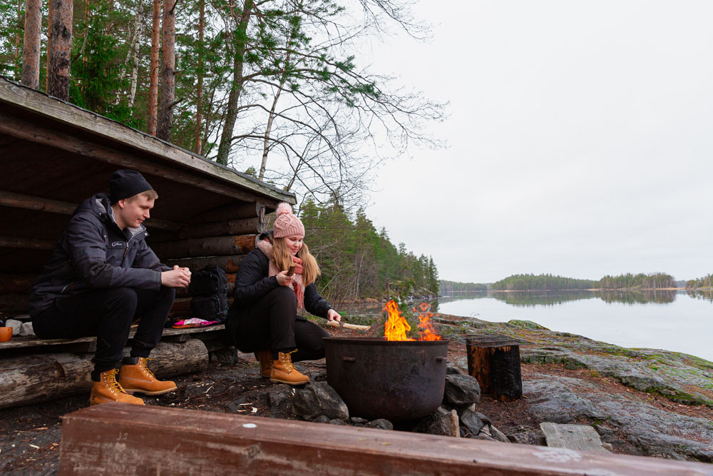 Two people at a lean-to shelter.